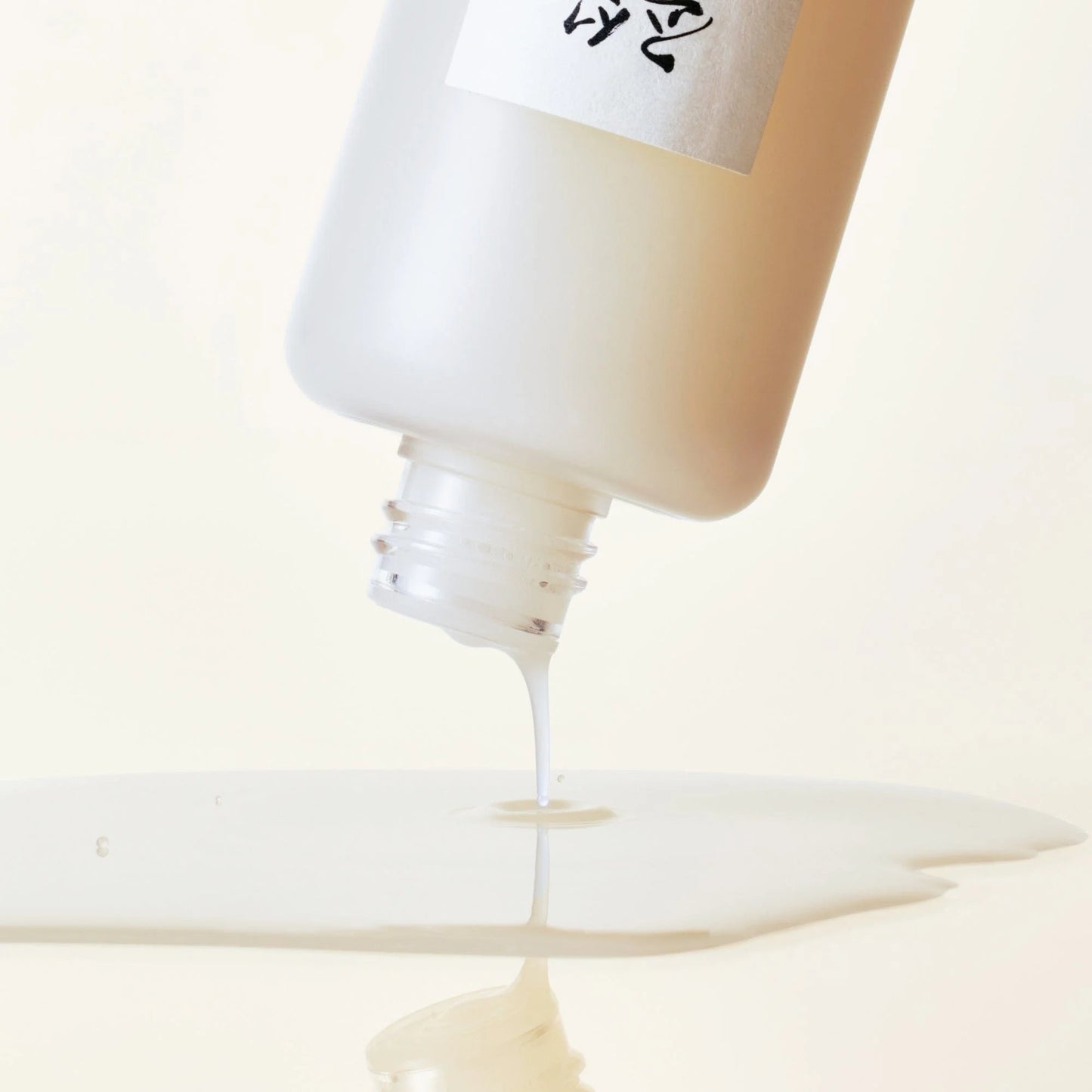 Beauty of Joseon GLOW REPLENISHING RICE MILK pouring from bottle, showcasing its hydrating formula.